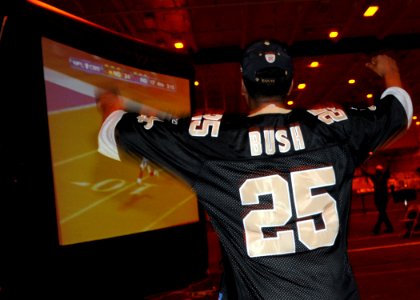 US Navy 100207-N-6509M-017 Boatswain's Mate 2nd Class Derrick Davis, aboard the aircraft carrier USS George H.W. Bush (CVN 77), cheers as the New Orleans Saints scores a touchdown during the Super Bowl