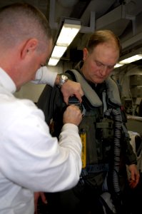 US Navy 100205-N-2475A-049 Aircrew Survival Equipmentman 1st Class Michael Kraus, left, from Mesa, Ariz., assists Capt. Joseph W. Kuzmick