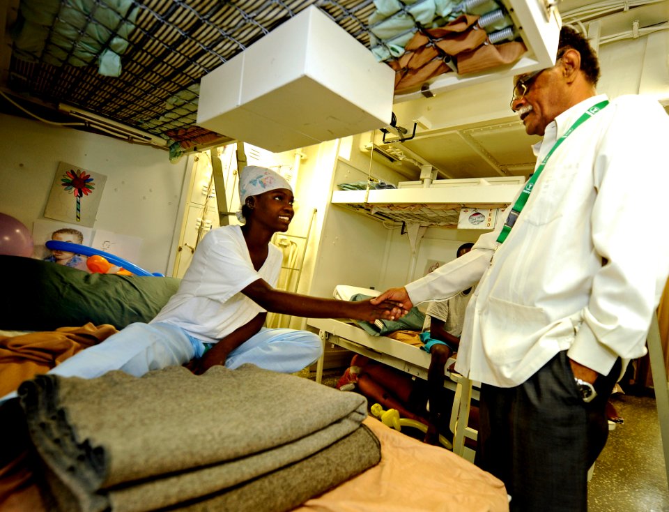 US Navy 100206-N-5345W-141 Dr. Alex Larsen, the Minister of Public Health in Haiti, speaks with a Haitian patient in the medical ward aboard the amphibious assault ship USS Bataan (LHD 5)