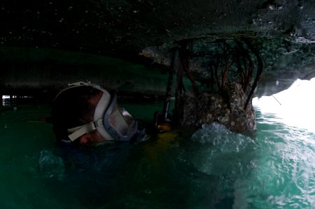 US Navy 100205-N-1134L-064 Steelworker 1st Class William Butcher, assigned to Underwater Construction Team (UCT) 1, drills guide holes into a damaged section of a pier at the port in Port-au-Prince, Haiti