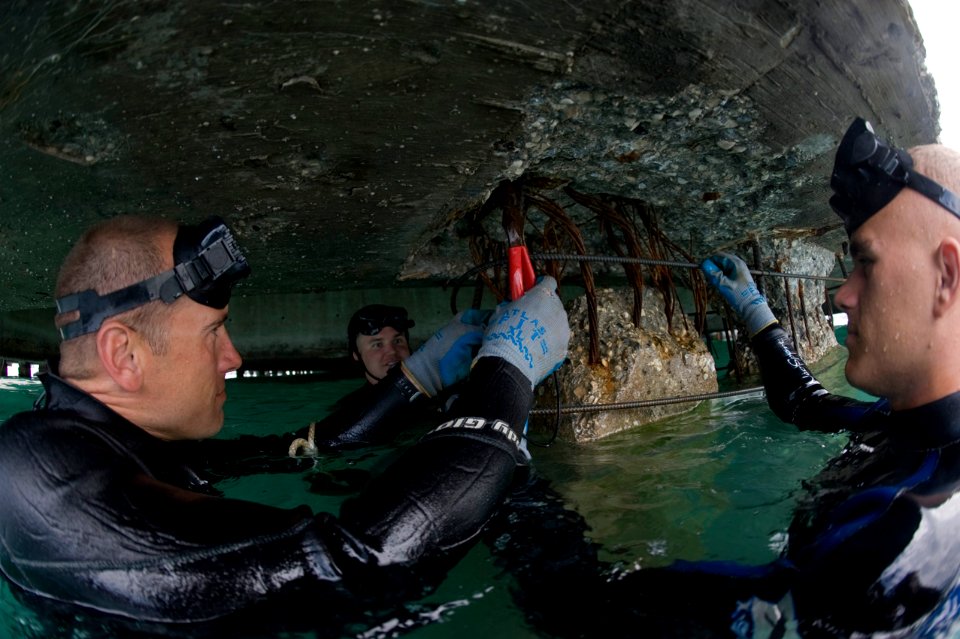 US Navy 100208-N-1134L-195 Divers wraps wire around adjoining pieces of re-enforcement bar used to strengthen sections of pier in Port-au-Prince, Haiti