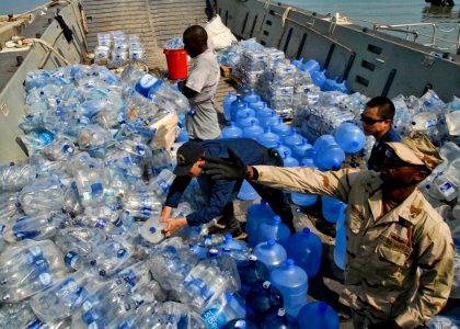 US Navy 100205-N-5787K-005 Sailors assigned to the amphibious dock landing ship USS Gunston Hall (LSD 44) unload water from a landing craft for distribution in Killick, Haiti photo
