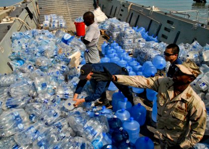 US Navy 100205-N-5787K-005 Sailors assigned to the amphibious dock landing ship USS Gunston Hall (LSD 44) unload water from a landing craft for distribution in Killick, Haiti