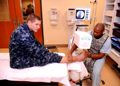 US Navy 100208-N-6326B-010 Aviation Boatswain's Mate (Handling) Airman Thomas E. Payne, assigned to the aircraft carrier USS Nimitz (CVN 68), has his fractured ankle evaluated using a bedside X-ray machine photo