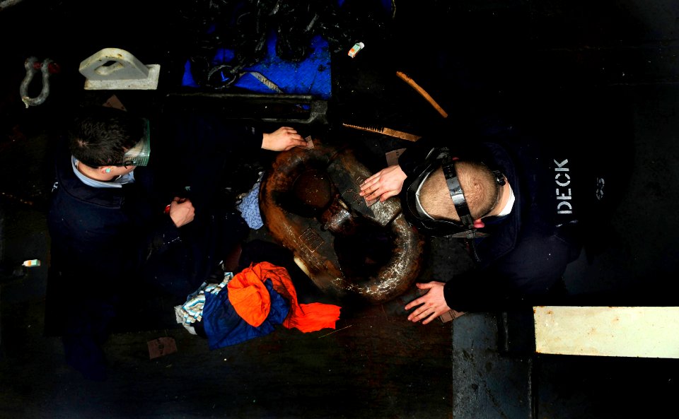 US Navy 100204-N-9928E-007 Sailors sand an anchor chain link in the forecastle aboard the Nimitz-class aircraft carrier USS John C. Stennis (CVN 74)