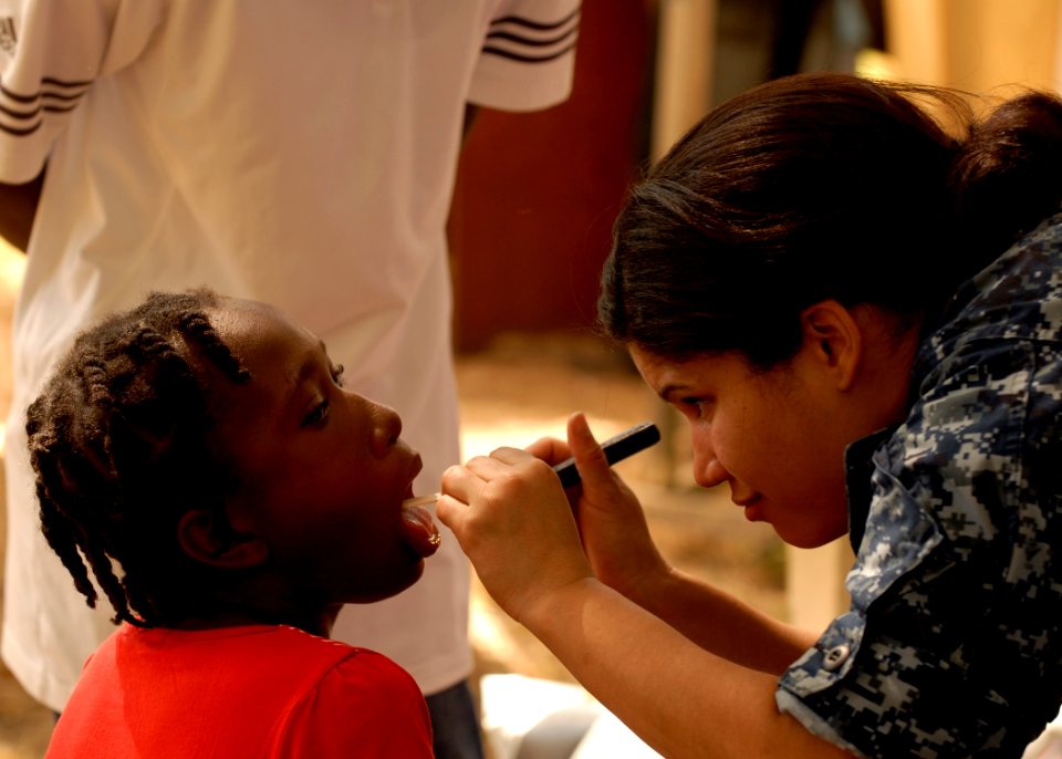 US Navy 100206-N-2000D-148 Lt. Dalia Figueroa, from Puerto Rico, a medical officer aboard the amphibious dock landing ship USS Carter Hall (LSD 50), examines a at a field treatment camp at the Hospital Cardinal Leger