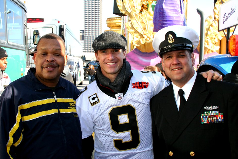 US Navy 100209-N-0000X-002 New Orleans Saints quarterback Drew Brees poses for a photo with Federal employee Joe Serals, left, and Senior Chief Interior Communications Specialist Perry Muller before the start of the New Orleans