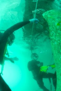 US Navy 100206-N-1134L-229 Divers rills guide holes into a damaged section of a pier at the port in Port-au-Prince, Haiti photo
