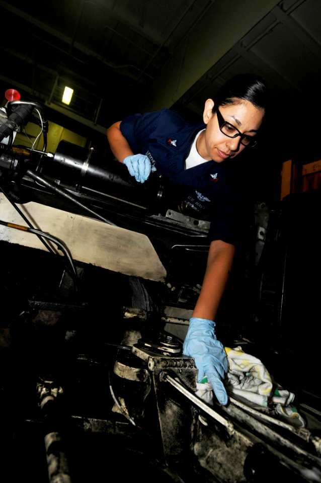 US Navy 100206-N-3038W-110 Aviation Support Equipment Technician 2nd Class Martha Moreno cleans the engine compartment of an aircraft tow tractor aboard the aircraft carrier USS Nimitz (CVN 68)