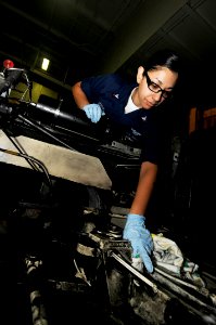 US Navy 100206-N-3038W-110 Aviation Support Equipment Technician 2nd Class Martha Moreno cleans the engine compartment of an aircraft tow tractor aboard the aircraft carrier USS Nimitz (CVN 68) photo