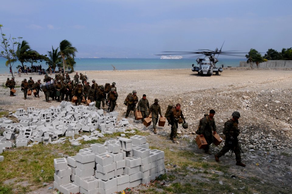 US Navy 100206-N-2735T-032 Marines from the 22nd Marine Expedition Unit (22nd MEU) carry supplies from an CH-53E Sea Stallion helicopter after arriving at the Civilian Military Operations Center in Carrefour, Haiti