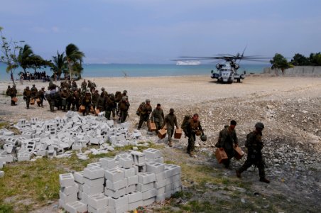 US Navy 100206-N-2735T-032 Marines from the 22nd Marine Expedition Unit (22nd MEU) carry supplies from an CH-53E Sea Stallion helicopter after arriving at the Civilian Military Operations Center in Carrefour, Haiti