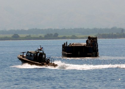 US Navy 100209-N-4971L-049 A security boat from Maritime Expeditionary Security Squadron (MSRON) 6 patrols the area while a landing craft utility departs the amphibious dock landing ship USS Fort McHenry (LSD 43)