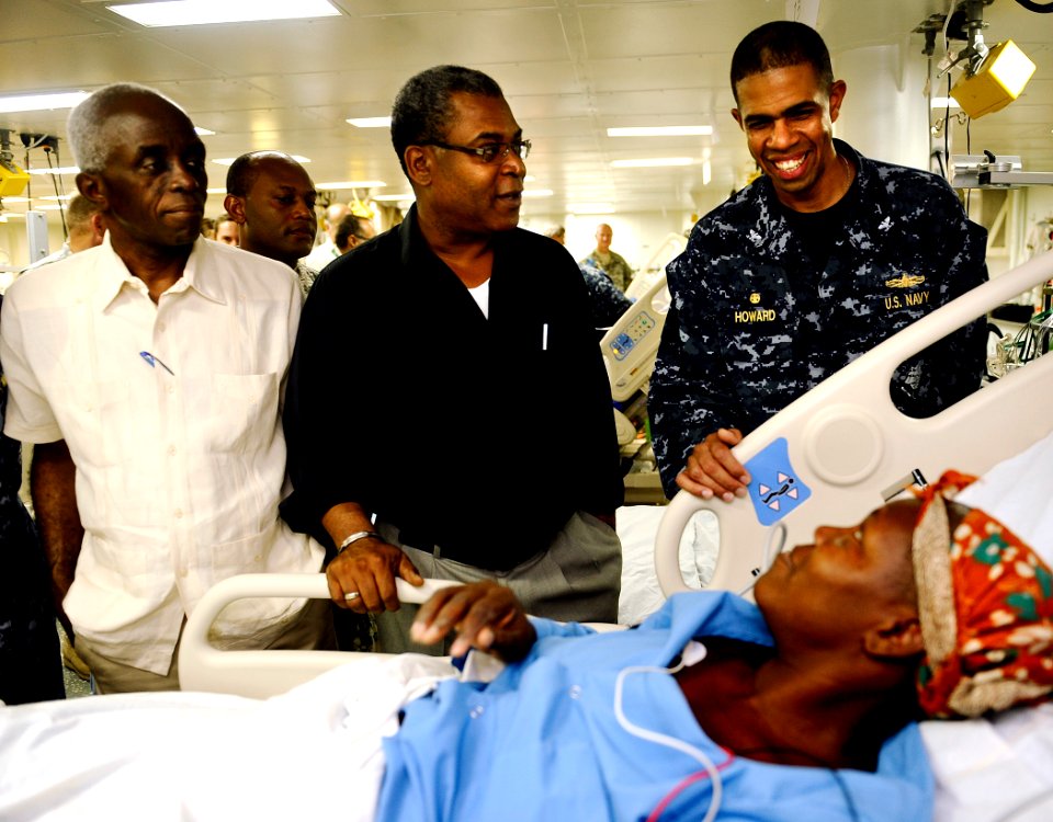 US Navy 100206-N-5345W-130 Capt. Sam Howard, commanding officer of the amphibious assault ship USS Bataan (LHD 5), right, visits Haitian patients in the medical ward with Haitian Prime Minister Jean-Max Bellerive