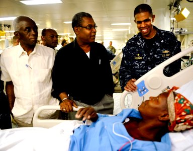 US Navy 100206-N-5345W-130 Capt. Sam Howard, commanding officer of the amphibious assault ship USS Bataan (LHD 5), right, visits Haitian patients in the medical ward with Haitian Prime Minister Jean-Max Bellerive