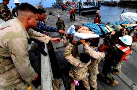 US Navy 100206-N-7948C-056 Sailors move an injured Haitian woman returning home after being treated aboard the Military Sealift Command hospital ship USNS Comfort (T-AH 20) photo
