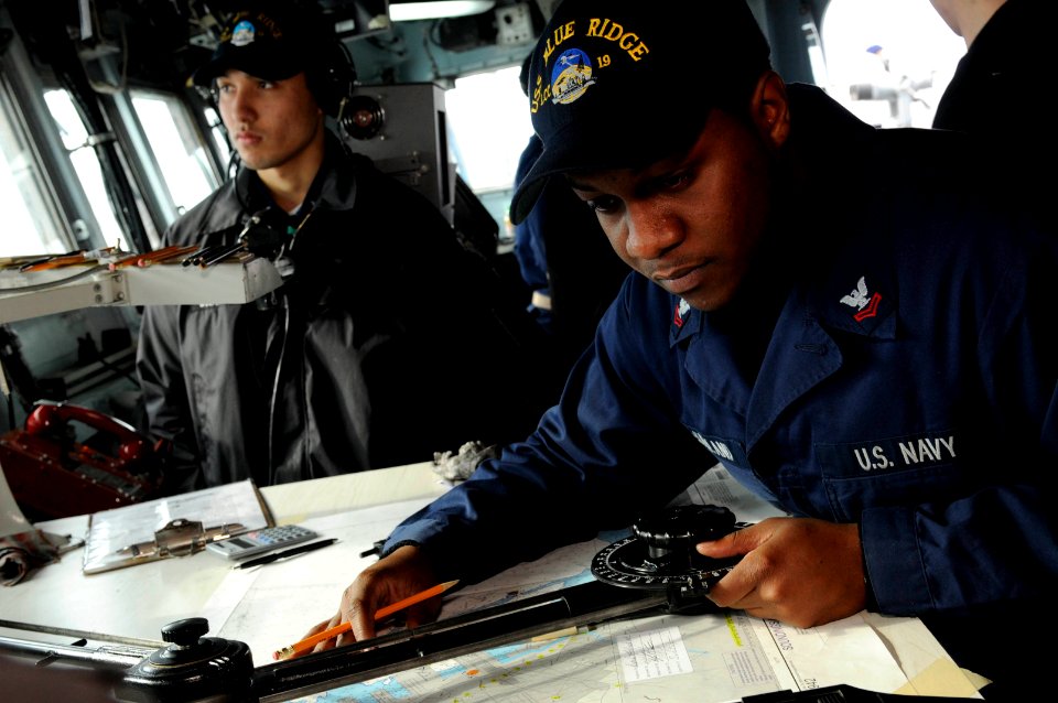 US Navy 100209-N-3830J-111 Quartermaster 2nd Class Dexter McFarland plots a navigational chart as the amphibious command ship USS Blue Ridge (LCC 19) gets underway from Otaru, Japan