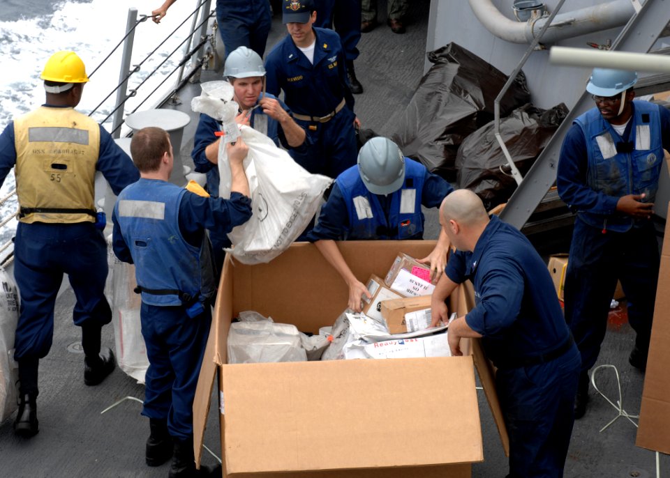 US Navy 100209-N-7088A-110 Sailors stationed aboard the Arleigh Burke-class guided-missile destroyer USS Farragut (DDG 99) unpack a pallet of mail during an underway replenishment