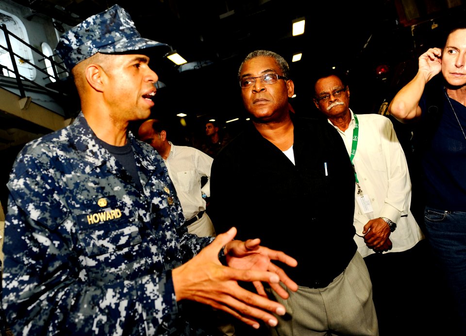 US Navy 100206-N-5345W-083 Capt. Sam Howard, commanding officer of the amphibious assault ship USS Bataan (LHD 5), explains his ship's well deck capabilities to Haitian Prime Minister Jean-Max Bellerive