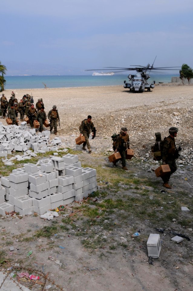 US Navy 100206-N-2735T-030 Marines from the 22nd Marine Expedition Unit (22nd MEU) carry supplies from a CH-53E Sea Stallion helicopter after arriving at the Civilian Military Operations Center in Carrefour, Haiti