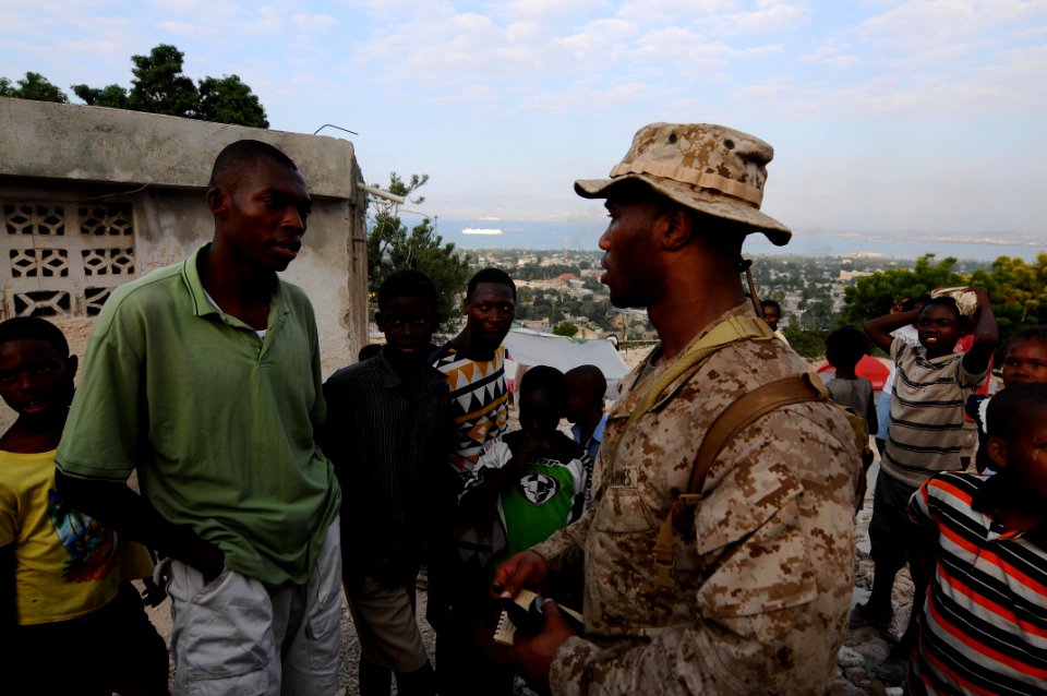 US Navy 100206-N-2735T-306 Cpl. Tristan Wilkerson, from New Orleans, assigned to the 24th Marine Expeditionary Unit (24th MEU), speaks to a community leader during a reconnaissance patrol
