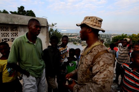 US Navy 100206-N-2735T-306 Cpl. Tristan Wilkerson, from New Orleans, assigned to the 24th Marine Expeditionary Unit (24th MEU), speaks to a community leader during a reconnaissance patrol
