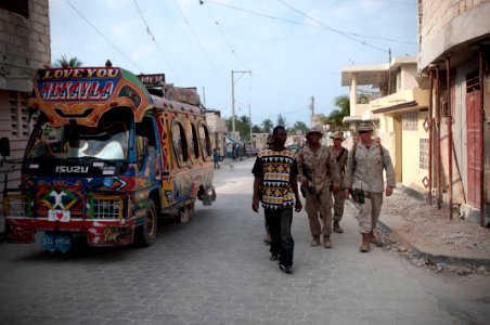 US Navy 100206-N-5712P-041 Marines from the 24th Marine Expeditionary Unit (24th MEU) patrol Carrefour, Haiti with Peterson Lezin, a Haitian citizen and Creole-to-English interpreter
