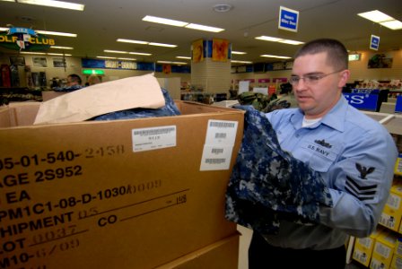 US Navy 100210-N-3283P-012 Culinary Specialist 1st Class Richard Rieth, assigned to the guided-missile destroyer USS John S. McCain (DDG 56), looks through the different components of the Navy Working Uniform