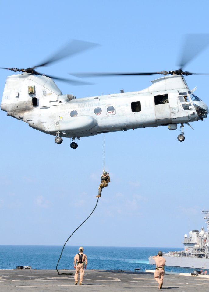 US Navy 100210-N-5538K-090 A visit, board, search and seizure team member, assigned to the 31st Marine Expeditionary Unit (31st MEU), fast ropes from a CH-46E Sea Knight helicopter
