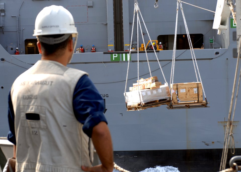 US Navy 100209-N-7088A-072 Lt. Mike Augustine, supply officer aboard the Arleigh Burke-class guided-missile destroyer USS Farragut (DDG 99), observes the transfer of supplies during an underway replenishment