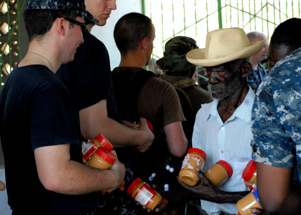 US Navy 100210-N-4971L-093 Engineman Fireman Recruit Patrick Shannon, from King's Mountain, N.C., assigned to the amphibious dock landing ship USS Fort McHenry (LSD 43), distributes peanut butter to Haitians in Birey, Haiti