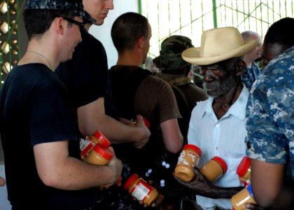 US Navy 100210-N-4971L-093 Engineman Fireman Recruit Patrick Shannon, from King's Mountain, N.C., assigned to the amphibious dock landing ship USS Fort McHenry (LSD 43), distributes peanut butter to Haitians in Birey, Haiti