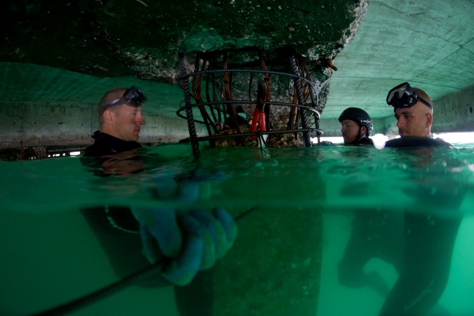 US Navy 100208-N-1134L-143 Divers wraps wire around adjoining pieces of re-enforcement bar used to strengthen sections of pier in Port-au-Prince, Haiti