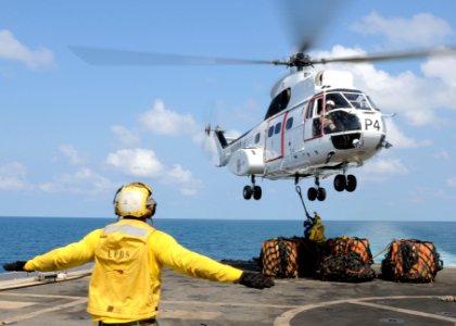 US Navy 100207-N-5538K-242 Aviation Boatswain's Mate Airman Tione M. Williams directs an SA-330J Puma helicopter photo
