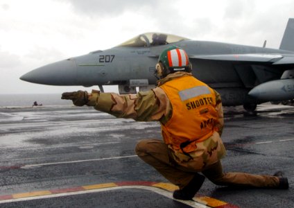 US Navy 100212-N-8822R-068 A flight deck shooter signals an F-A-18 Super Hornet for takeoff from USS Carl Vinson (CVN 70)