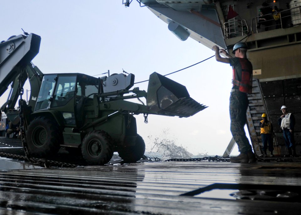 US Navy 100212-N-9950J-603 A Sailor directs a vehicle aboard USS Essex