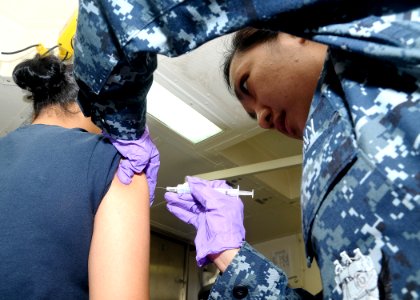 US Navy 100213-N-4649B-008 Hospital Corpsman 2nd Class Lucille Tabancay administers a shot to a patient aboard the multi-purpose amphibious assault ship USS Bataan (LHD 5) photo