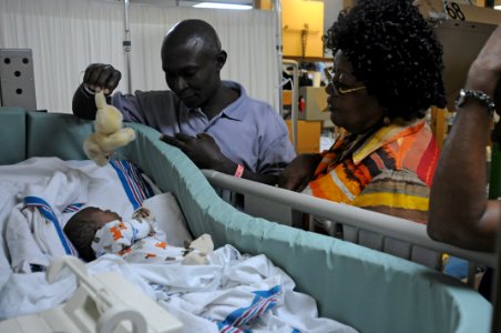 US Navy 100208-N-4995K-157 Jeanne Bernard Pierre, director of the Institute of Social Welfare in Haiti, visits an infant patient aboard the Military Sealift Command hospital ship USNS Comfort (T-AH 20) photo