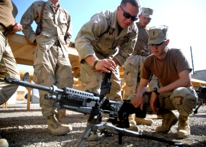 US Navy 100213-N-9564W-133 Gunner's Mate 2nd Class Bryan Silveri gives instruction to Lt. j.g. Richard Buechel on proper operation of the M-240B automatic machine gun