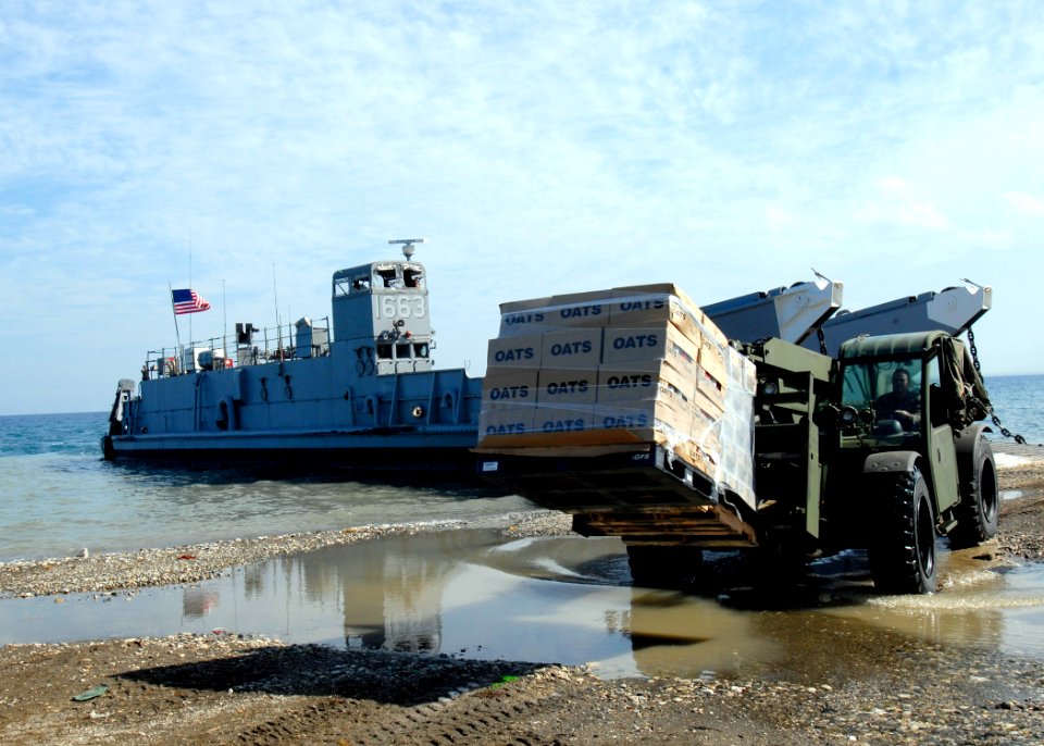 US Navy 100213-N-2000D-079 A Seabee assigned to Amphibious Construction Battalion (ACB) 2 delivers humanitarian supplies at a landing site in Grand Goave, Haiti