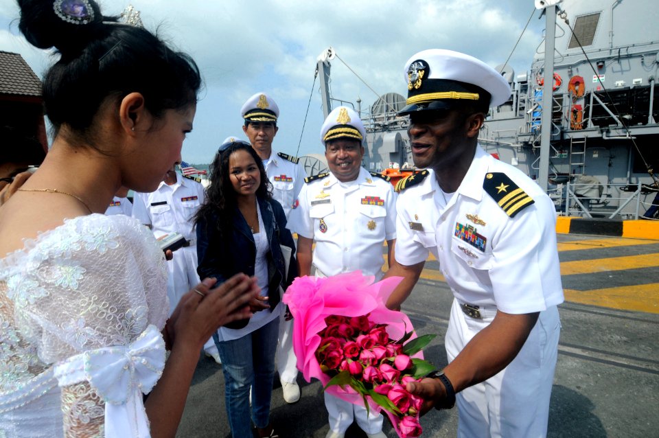 US Navy 100215-N-8335D-235 A Cambodian woman presents flowers to Lt. Cmdr. Walter Mainor