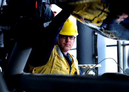 US Navy 100210-N-7478G-271 Seaman Joshua Gray seats a rigid hull inflatable boat after conducting a man overboard drill with a small boat recovery method aboard the U.S. 7th Fleet command ship USS Blue Ridge (LCC 19)