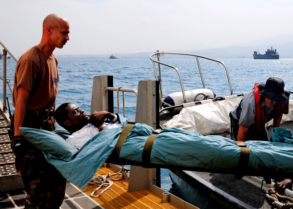 US Navy 100215-N-4378P-095 Culinary Specialist 1st Class Eric Oliver, from Saylorsburg, Pa., helps transport a Haitian patient being discharged from the Military Sealift Command hospital ship USNS Comfort (T-AH 20)