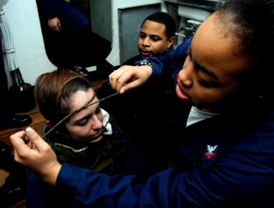 US Navy 100211-N-7280V-215 Information Systems Technician 2nd Class Jonetta McCoy simulates bandaging a facial wound on Information Systems Technician 2nd Class Lara Marsh during a chemical, biological and radiological drill