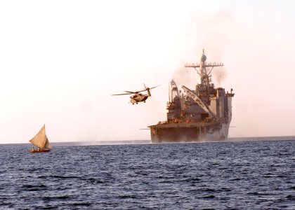 US Navy 100210-N-4971L-143 A helicopter takes off from the amphibious dock landing ship USS Fort McHenry (LSD 43) as a fishing boat sails past off the coast of Haiti