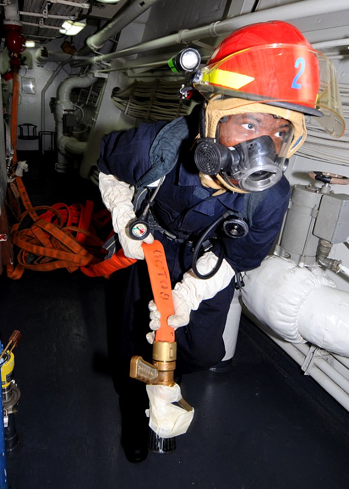 US Navy 100217-N-1082Z-018 Culinary Specialist Seaman Mario D. Swift, from Folkston, Ga., handles a hose during an engineering fire drill