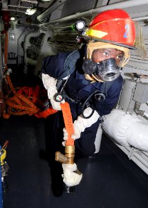 US Navy 100217-N-1082Z-018 Culinary Specialist Seaman Mario D. Swift, from Folkston, Ga., handles a hose during an engineering fire drill