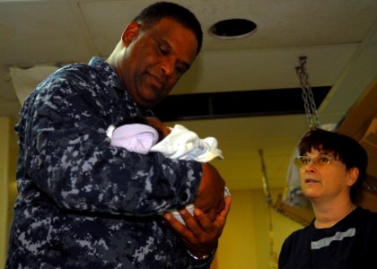 US Navy 100217-N-1092P-077 Rear Adm. Victor G. Guillory, commander of U.S. Naval Forces Southern Command, holds the child of a Haitian woman receiving medical care aboard the Military Sealift Command hospital ship USNS Comfort photo