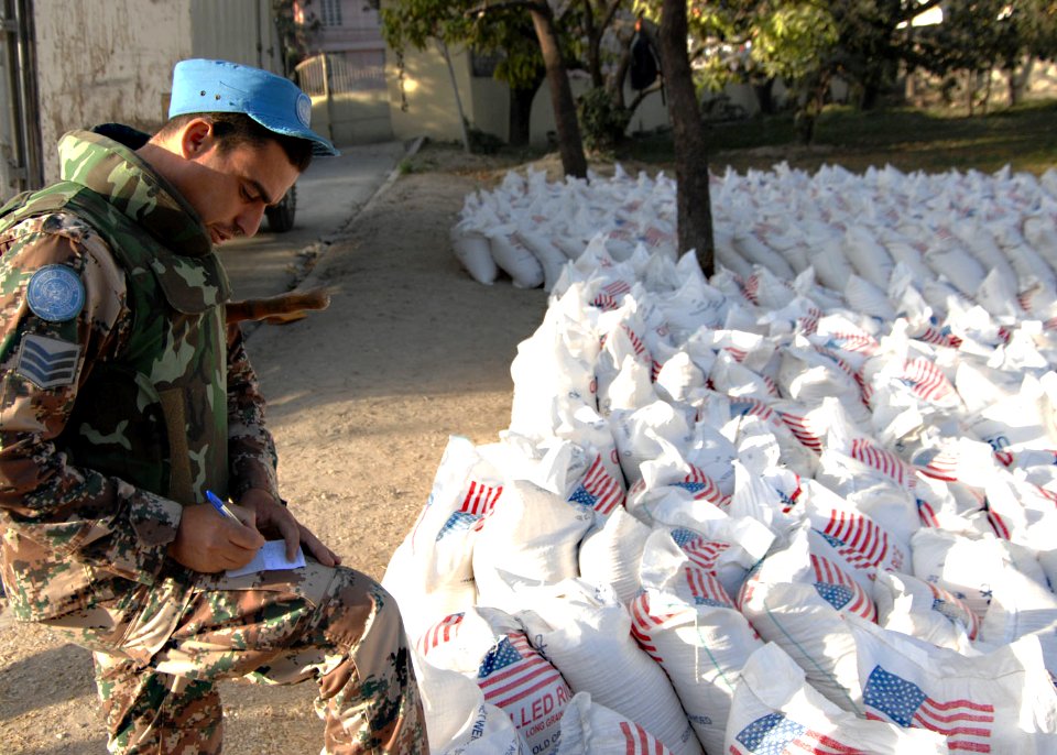 US Navy 100213-N-5961C-001 A Jordan U.N. peacekeeper prepare to distribute 904 bags of rice at an aid distribution point in Port-au-Prince, Haiti