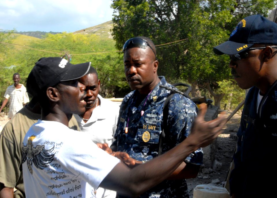 US Navy 100212-N-7638K-034 Master Chief Andrew Thompson land Chief Hull Technician Jeffery Middleton discuss with a Haitian translator where to place building materials